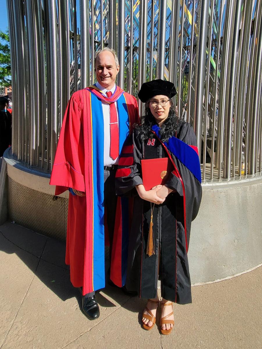 Dr. Laurence Rilett and Huong Pham wearing graduation ceremony gowns.