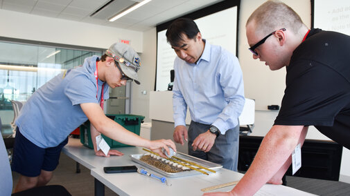 Dr. Nathan Huynh, NTC Director, guides students to build and test a railroad track.