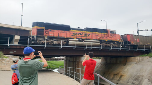 Students watching as a train passes overhead.