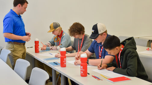 Engineer assisting students in activity.