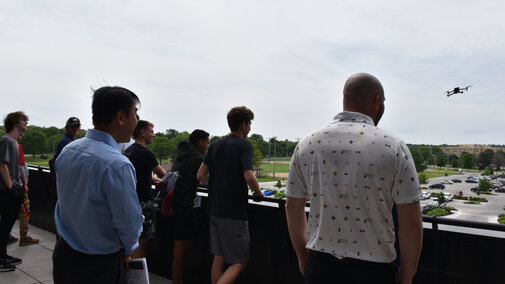 Program participants watch a demonstration of a drone.