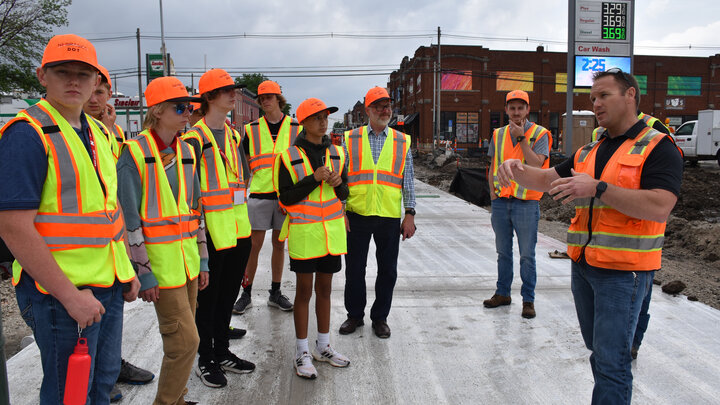 Students standing on a road during a tour of a construction site.