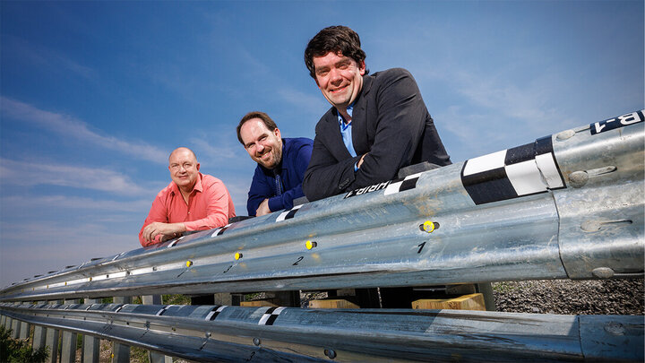 Cody Stolle, Josh Steelman, and Ronald Faller lean against a guardrail.