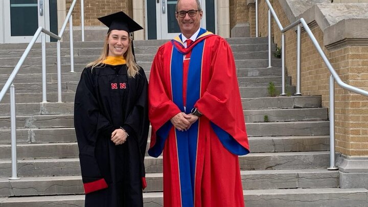 Sydney James and Dr. Laurence Rilett in graduation ceremony robes