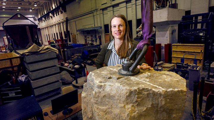 Dr. Christine Wittich in her lab with a suspended block of concrete