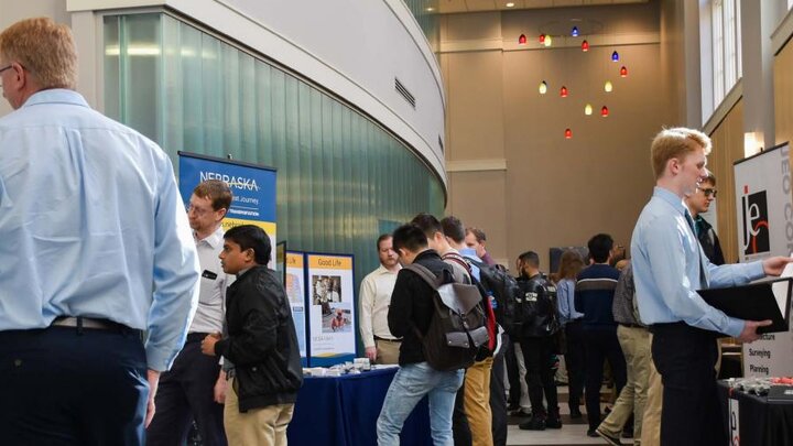 Students and industry professionals mingle amongst information booths