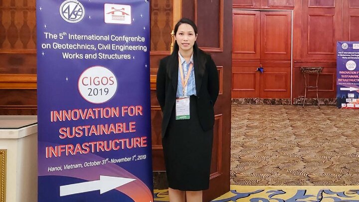 Huong Pham standing next a poster with Innovation For Sustainable Infrastructure written on it