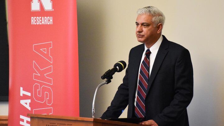 Dr. Aemal Khattak at a podium with a microphone