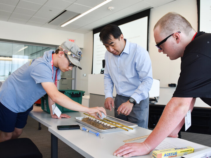 Dr. Nathan Huynh, NTC Director, guides students to build and test a railroad track.