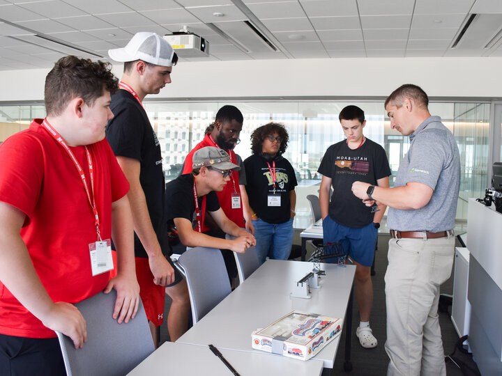 Benesch employee showing models of railroad bridges to students.