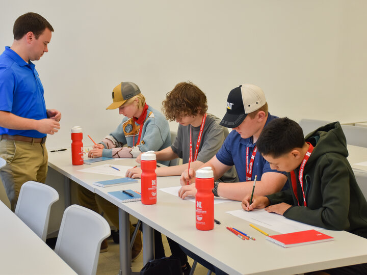 Engineer assisting students in activity.