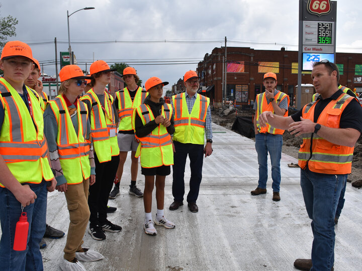 Students standing on a road during a tour of a construction site.