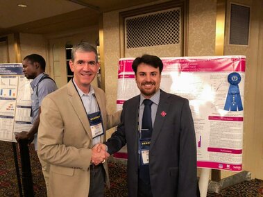 Student and faculty in front of research poster