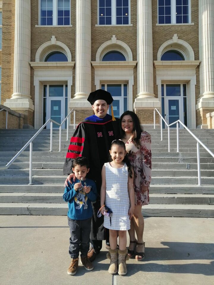 Antonio in his graduation robes with his family