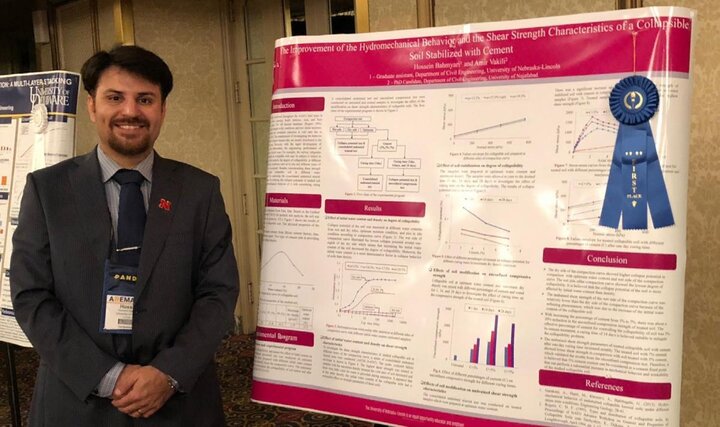 Hossein Bahmyari standing in front of research poster with a blue ribbon